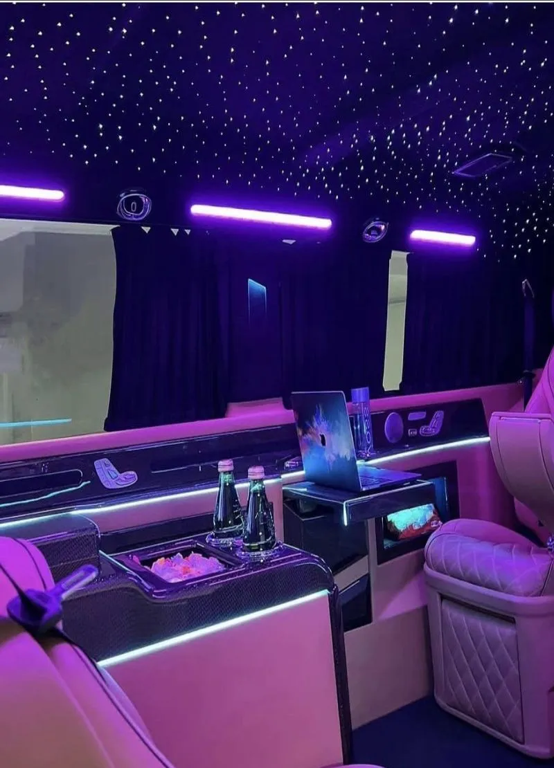 A lounge van cabin with a starlight ceiling, ambient lighting and quilted leather captain’s chairs